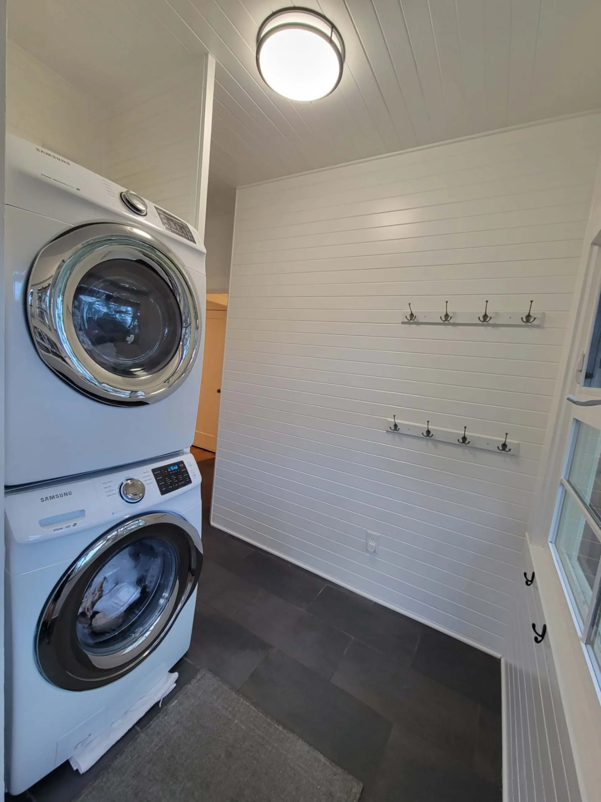 Freshly painted white laundry room with tile in a Hood River home