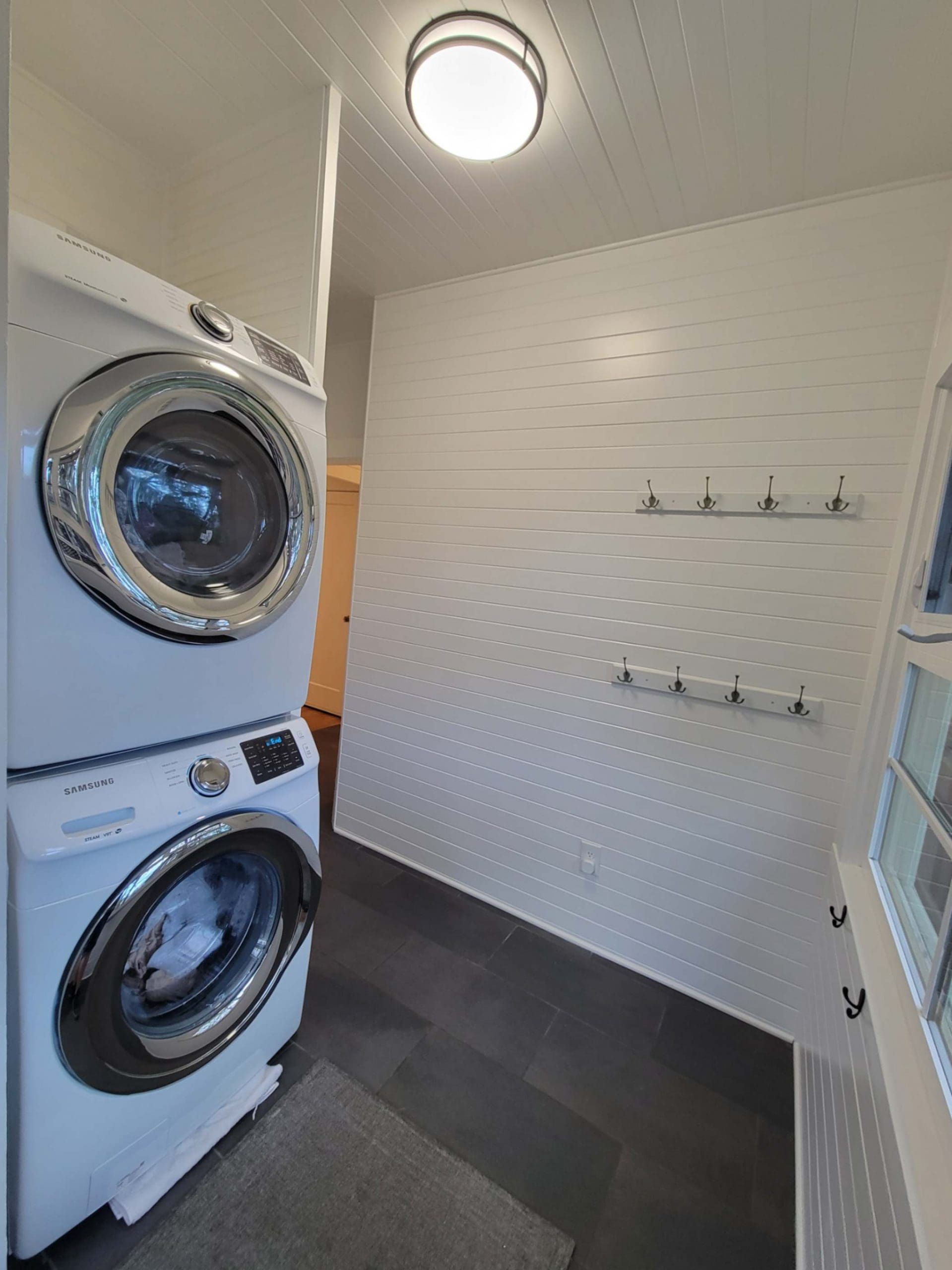 Freshly painted white laundry room with tile in a Hood River home