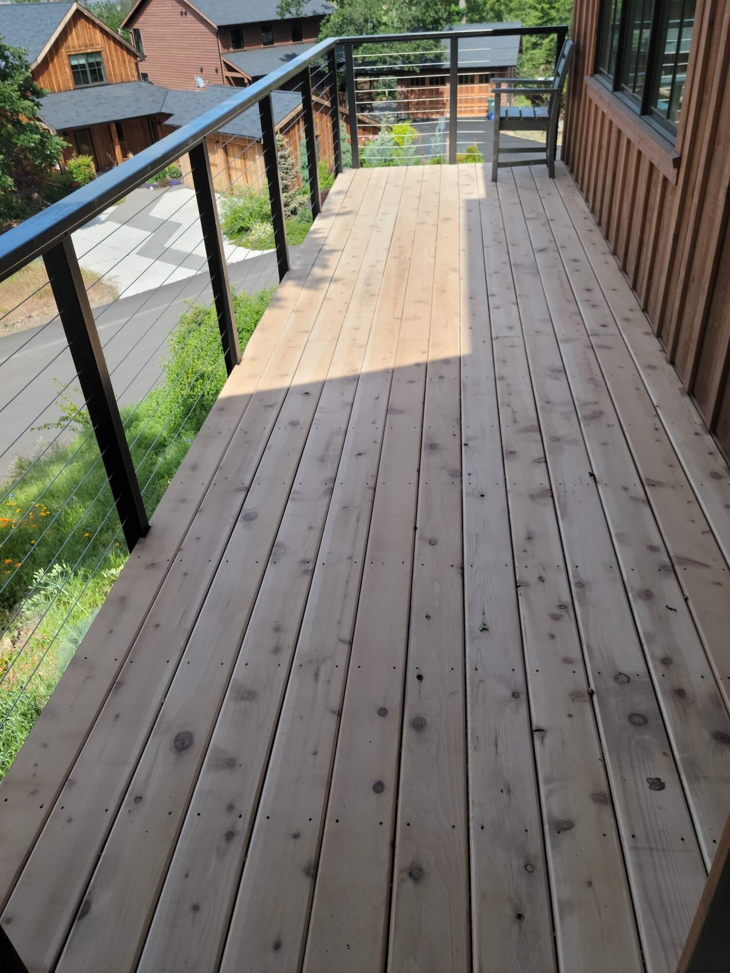 Painter brushing stain onto wood decking at an Odell, OR home