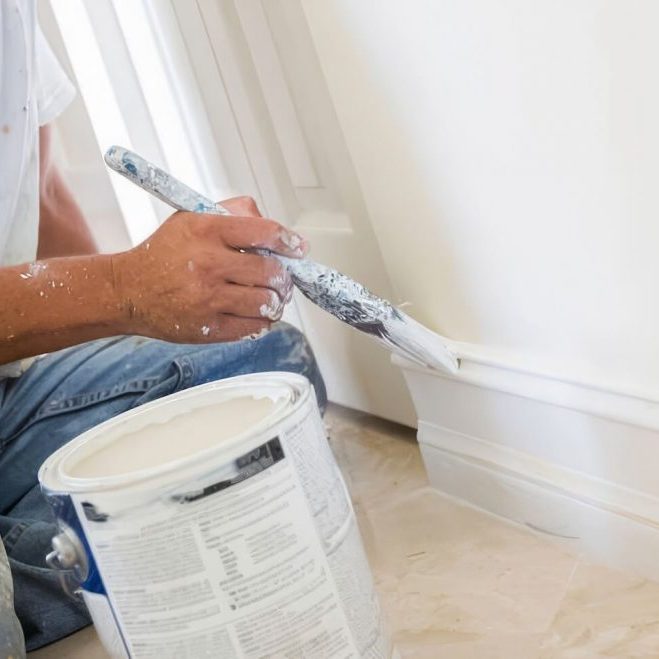 Painter cutting a clean line around a window in a Hood River home