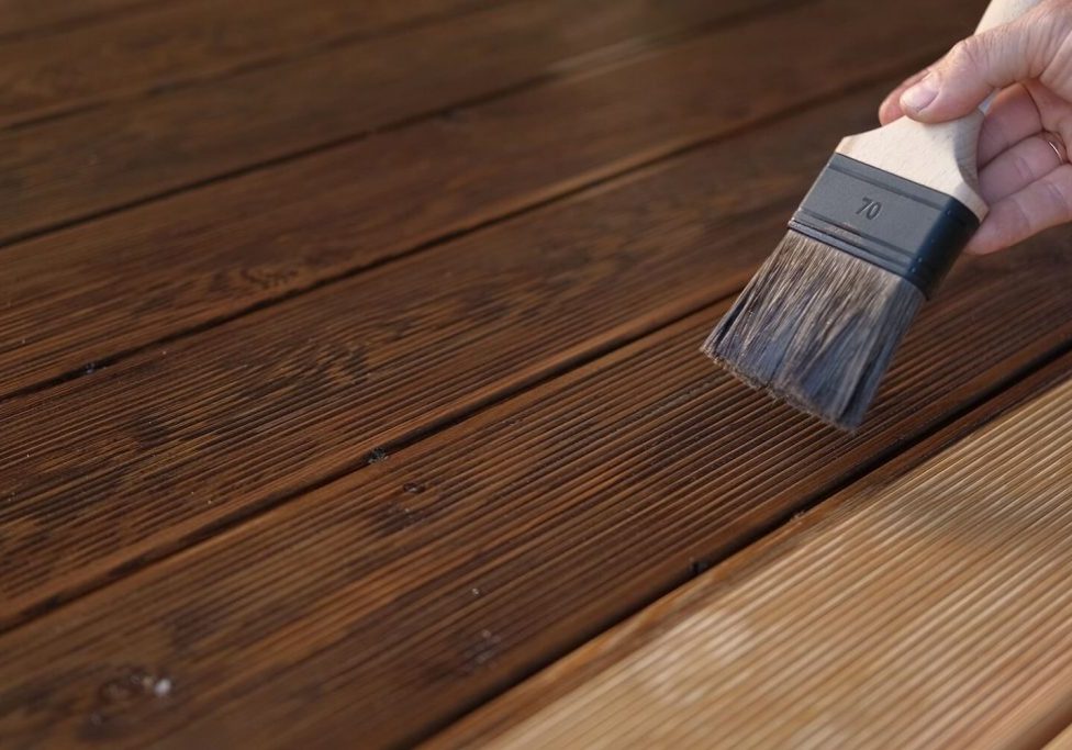 painter back-brushing exterior siding for lasting adhesion